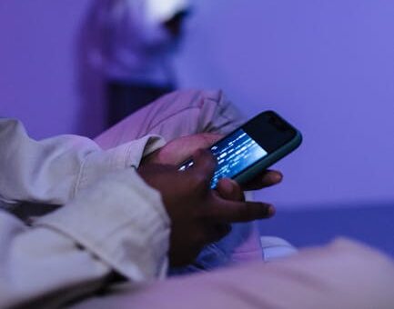 Focused teens using smartphones indoors, creating a modern tech atmosphere.